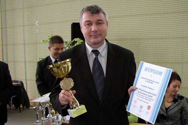 Dyrektor szkoy z pamiatkowym dyplomem i pucharem